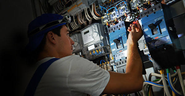Electrician wiring a commercial control panel